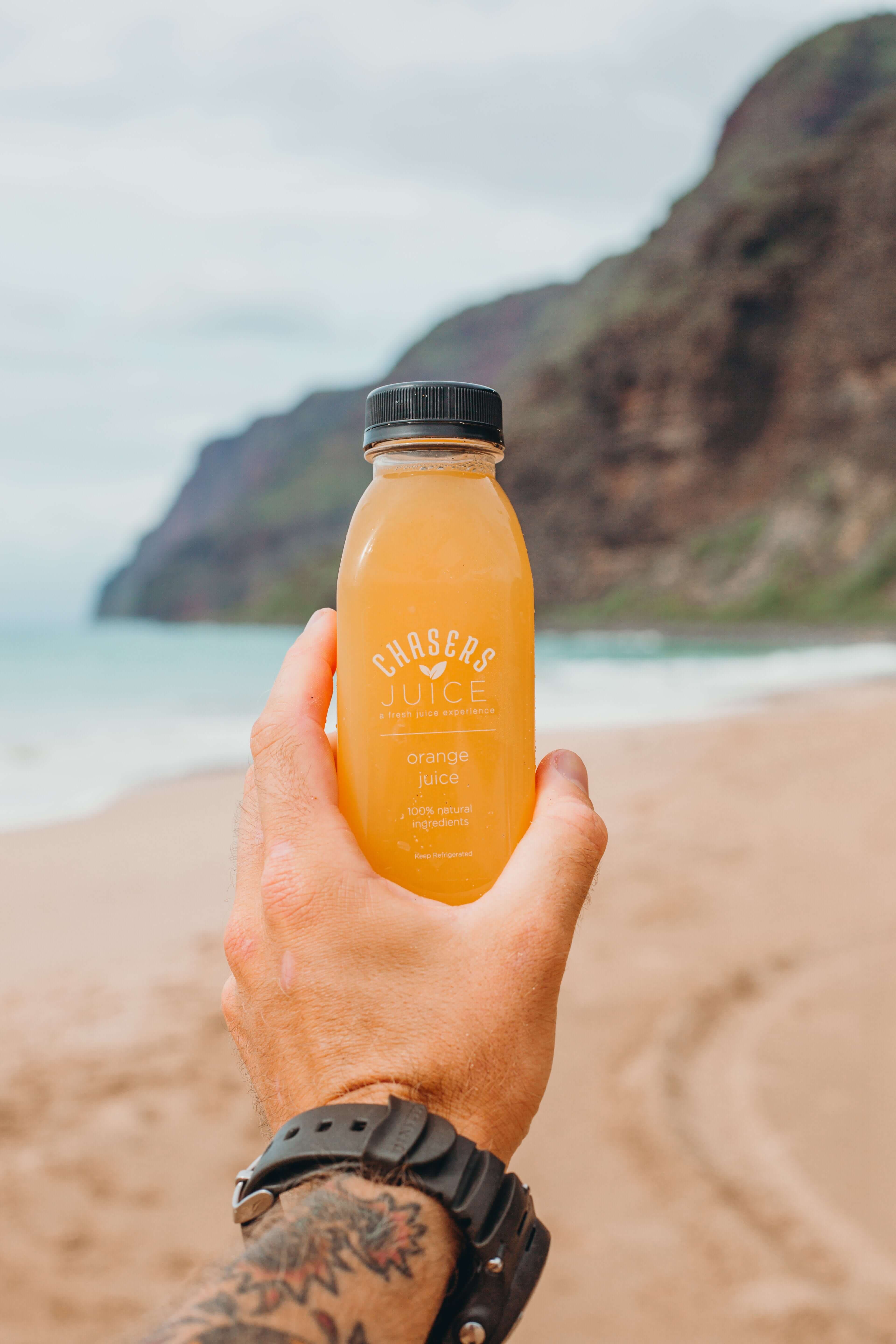 Hand holding bottle of orange juice